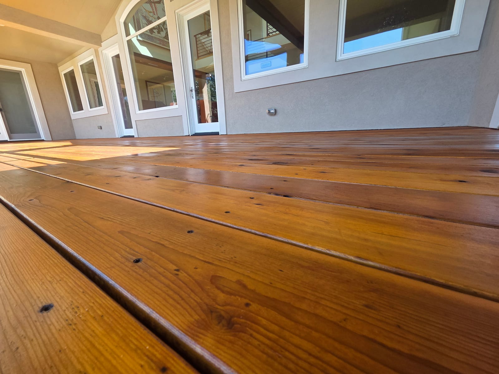Close-up ground-level view of the finished deck showing even penetrating stain absorption