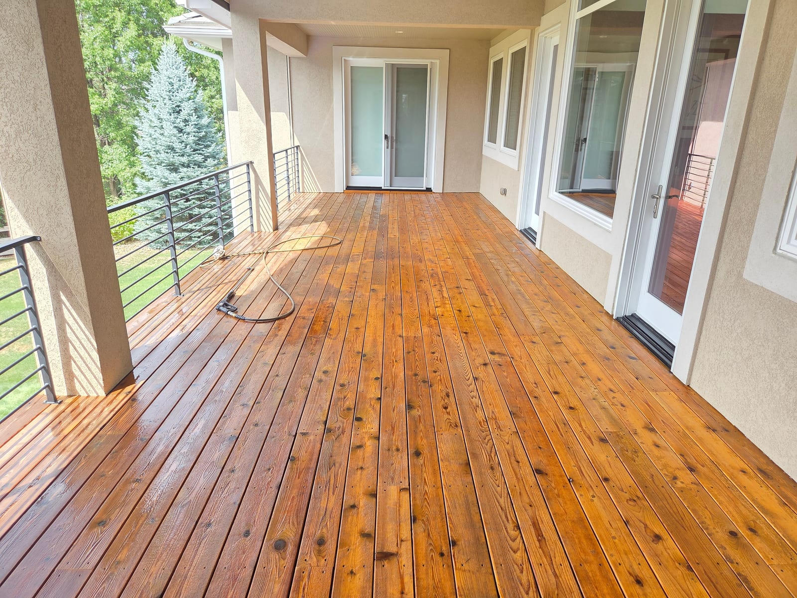 Wide shot of the deck after washing, boards drying in the sun before staining